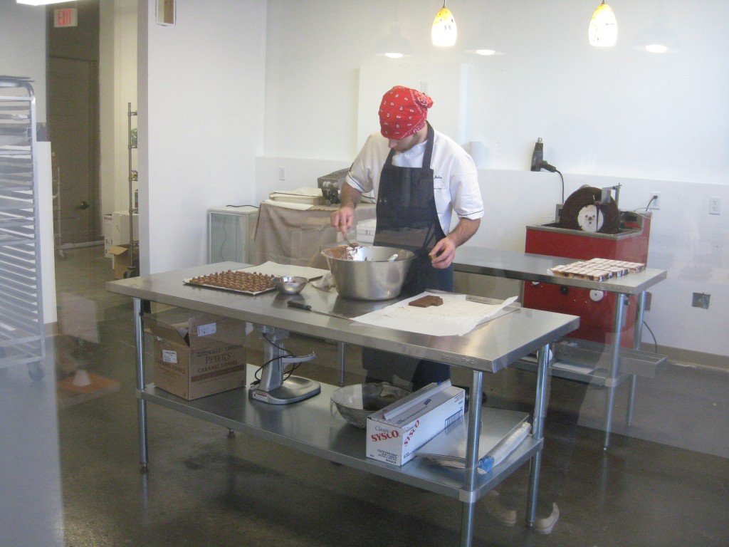 Julien making chocolates as viewed through the viewing room in the retail shop.